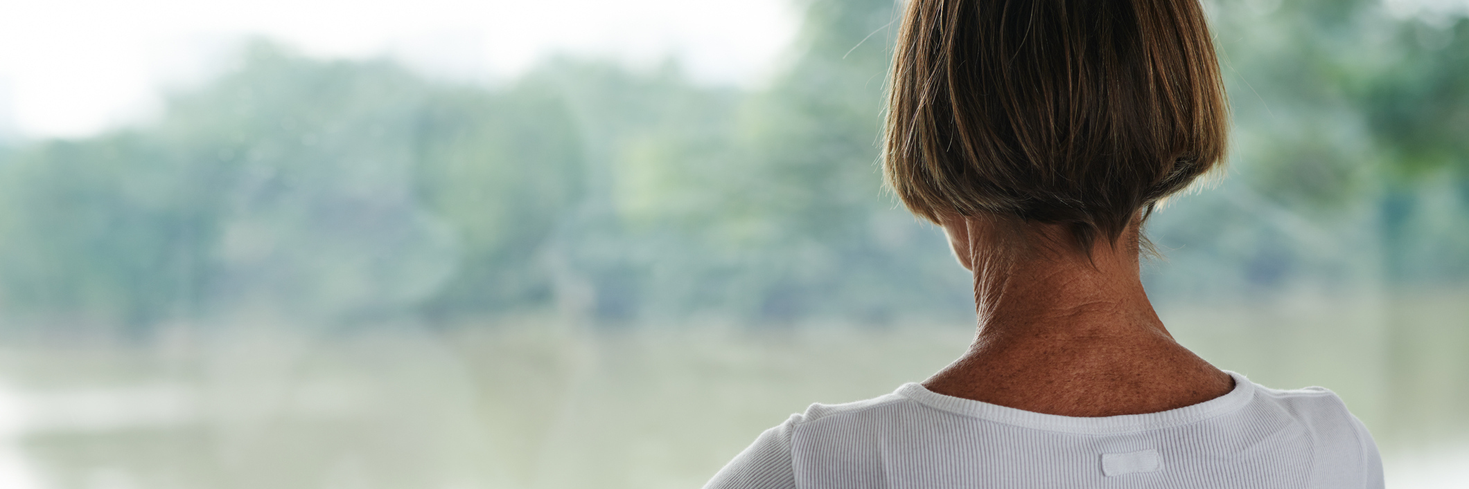 Surprising Symptoms and Aspects of Fibromyalgia woman meditating and sitting next to a lake