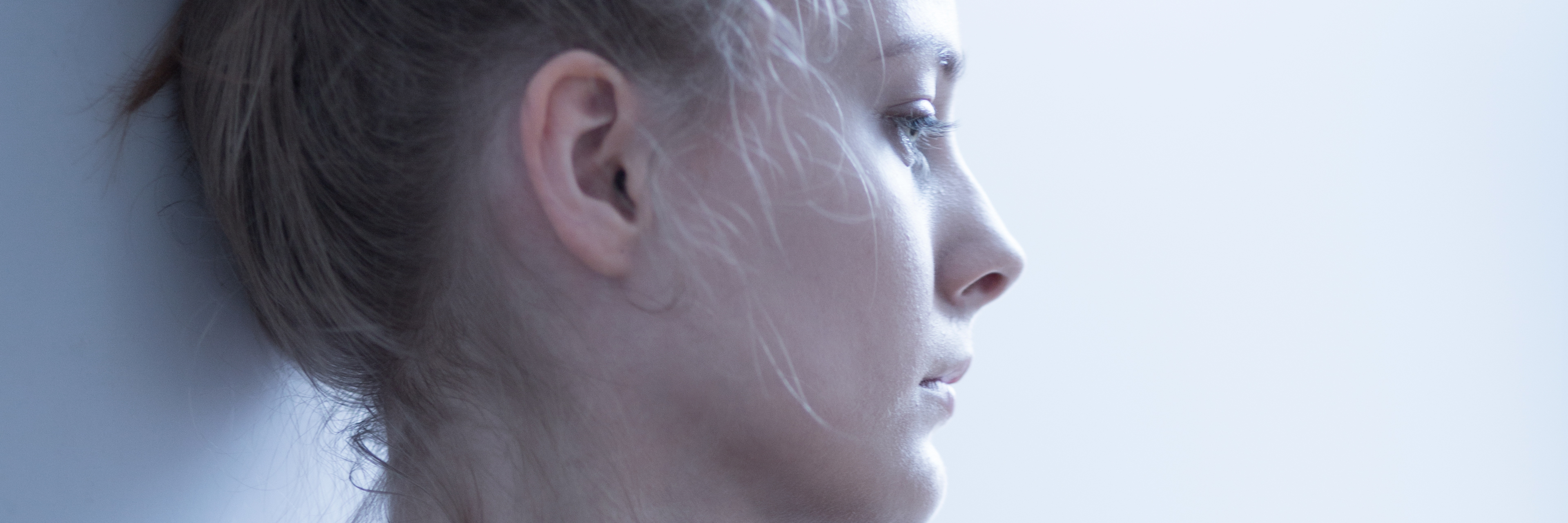 Worrying About Having Children With Polycystic Ovary Syndrome (PCOS) woman leaning against a wall and looking worried