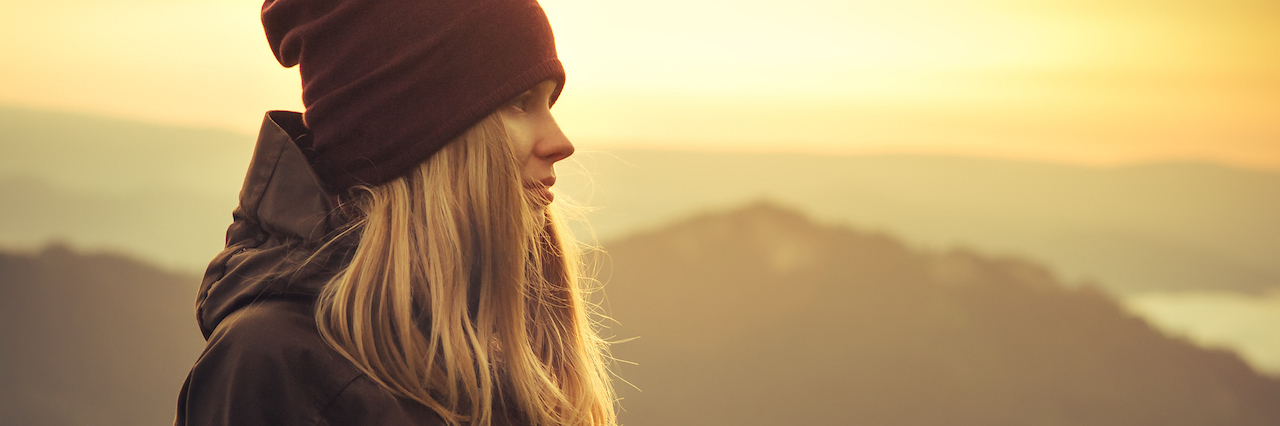 I Will No Longer Keep My Eating Disorder a Secret A woman standing on a mountain looking at the view