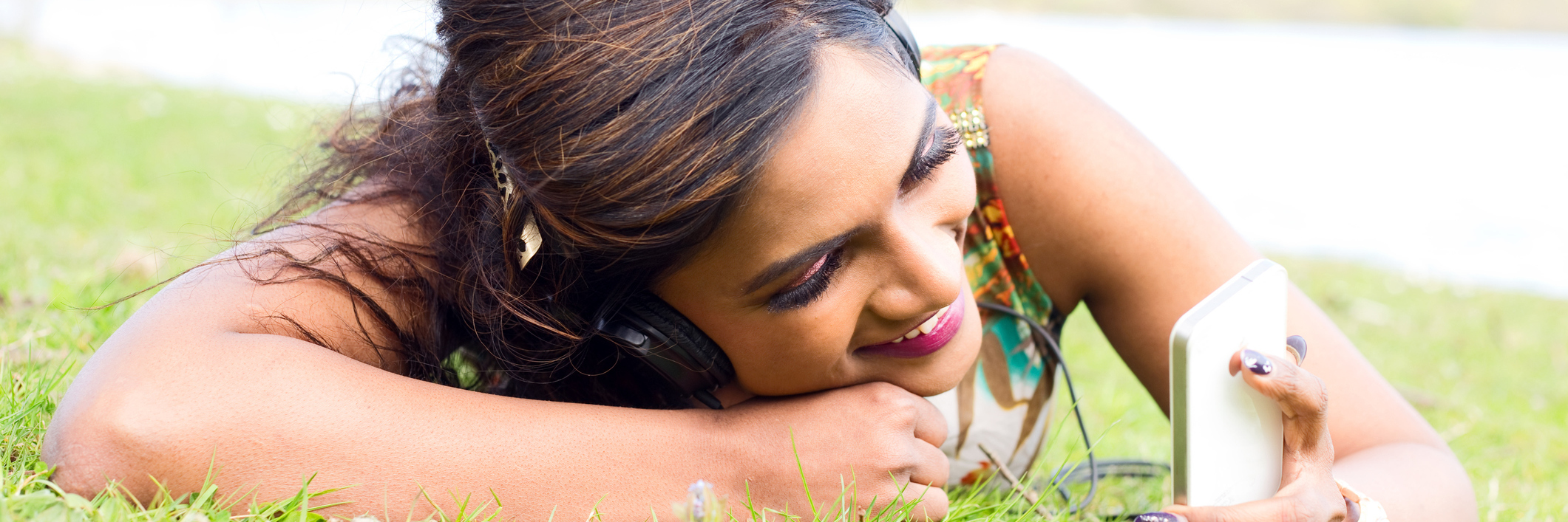 woman lying in the grass and listening to music