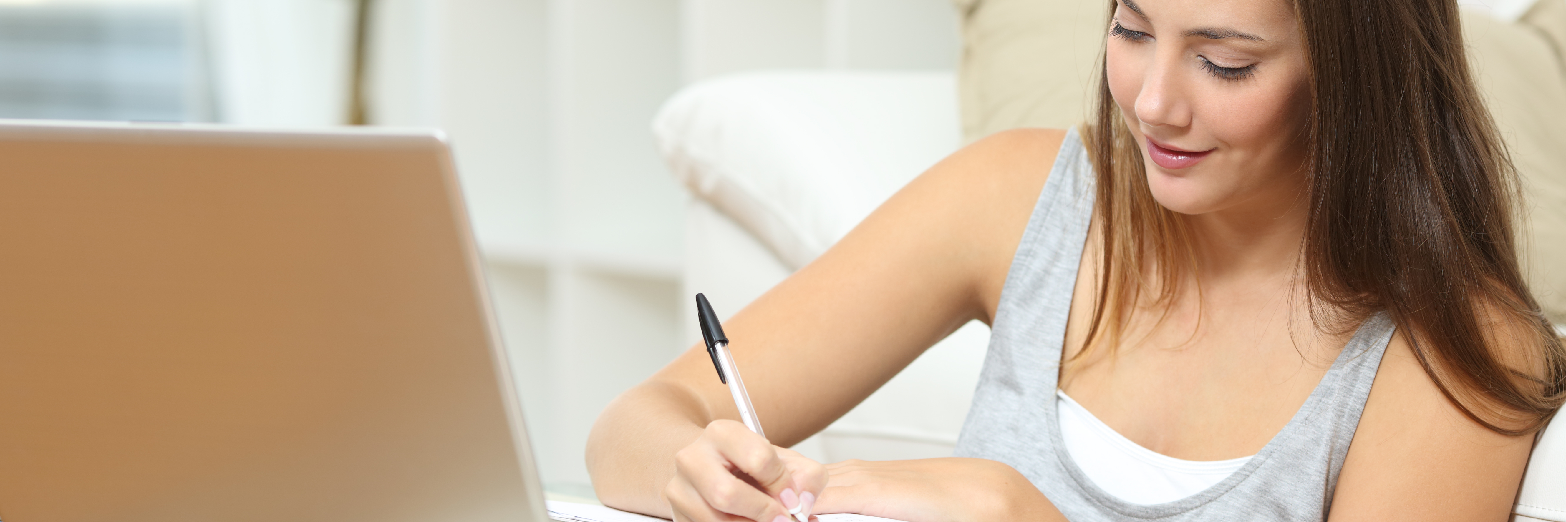 How Writing Helps My Anxiety young woman with notebook and laptop writing at home