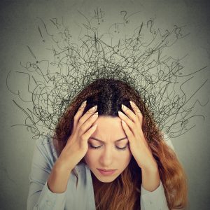 close up photo of woman with hands on head with lines coming from head in messy way