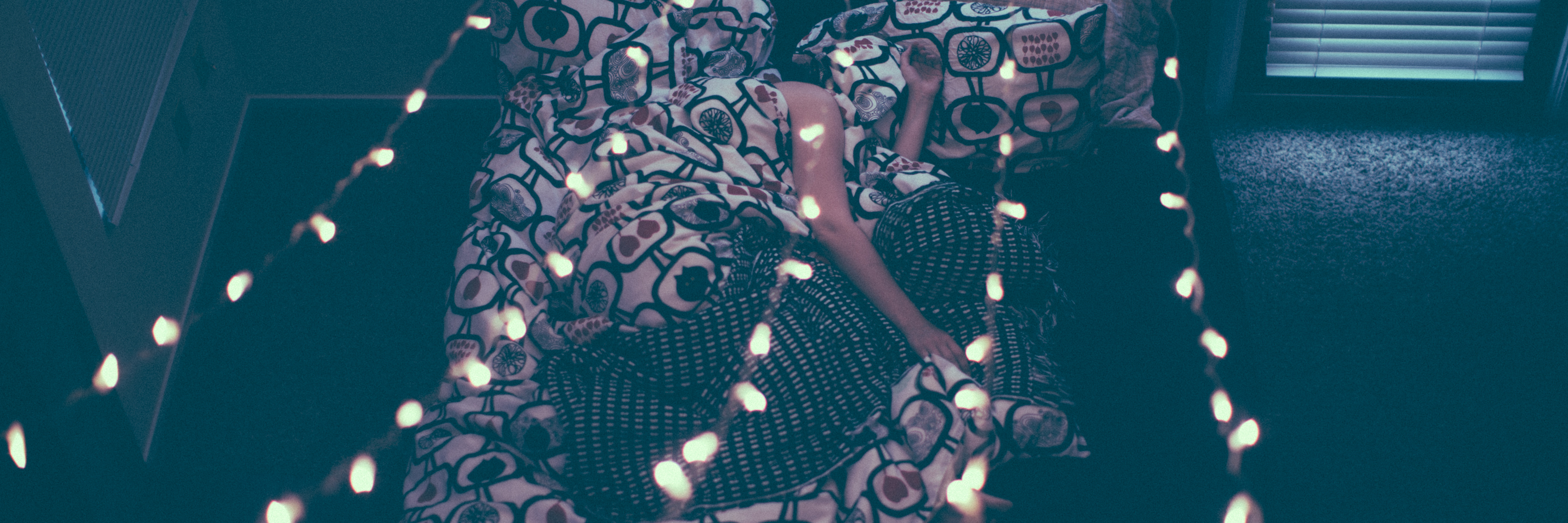 When You're Ready to Live With Depression and Not Just Survive overhead photo of woman lying in bed with lights above her covered with duvet