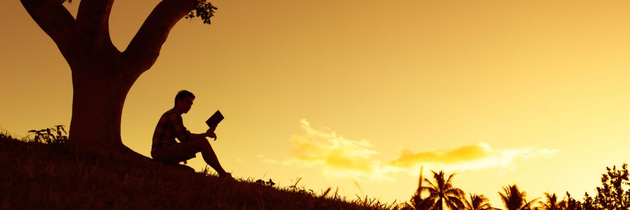 Why Special Interests Are Important for People on the Autism Spectrum Man reading book under tree in park at sunset