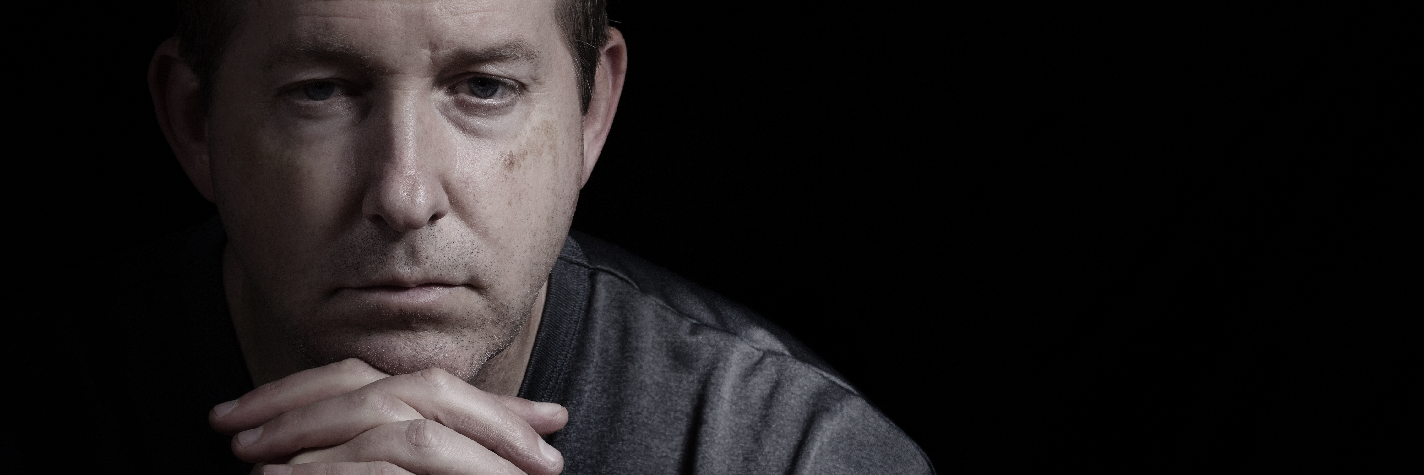 How My Depression Affects My Dating close up of mature man resting chin on hands in dark room