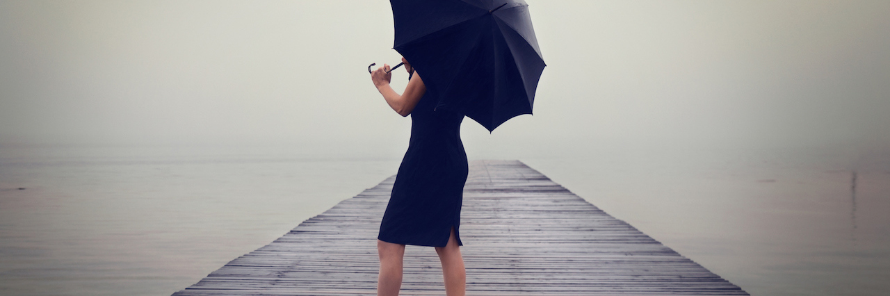 Why Depression Isn’t ‘Just Being Sad’ A woman with a black umbrella