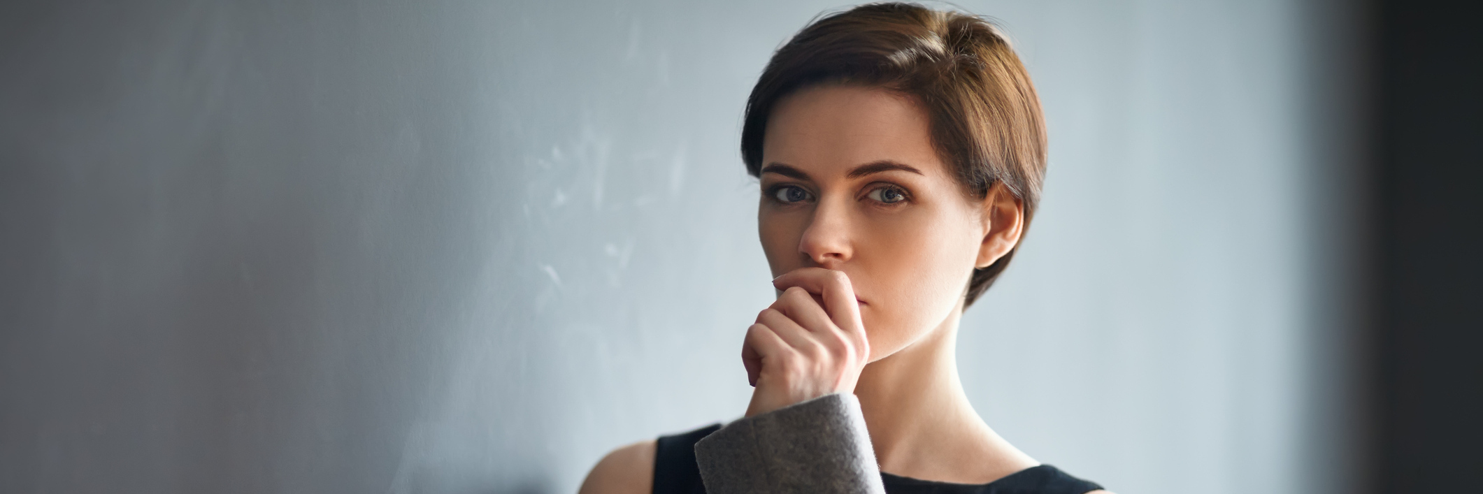 To the Girl I Once Knew, Before Chronic Illness Woman against wall, in deep thought.