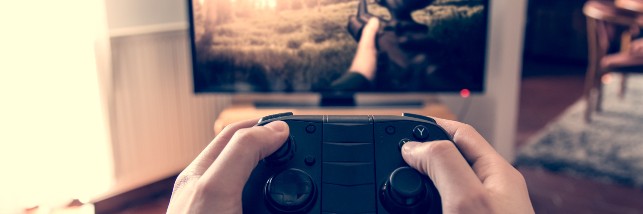 How Bipolar Disorder Can Affect 'Everyday Addictions' Hands holding game pad and playing shooter game on tv screen.