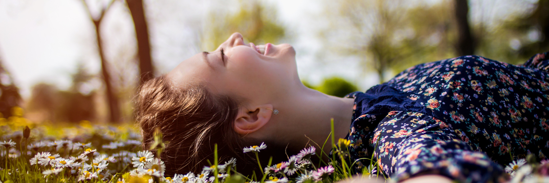 Traumatic Brain Injury: Finding Happiness During Recovery woman lying in field of flowers and smiling