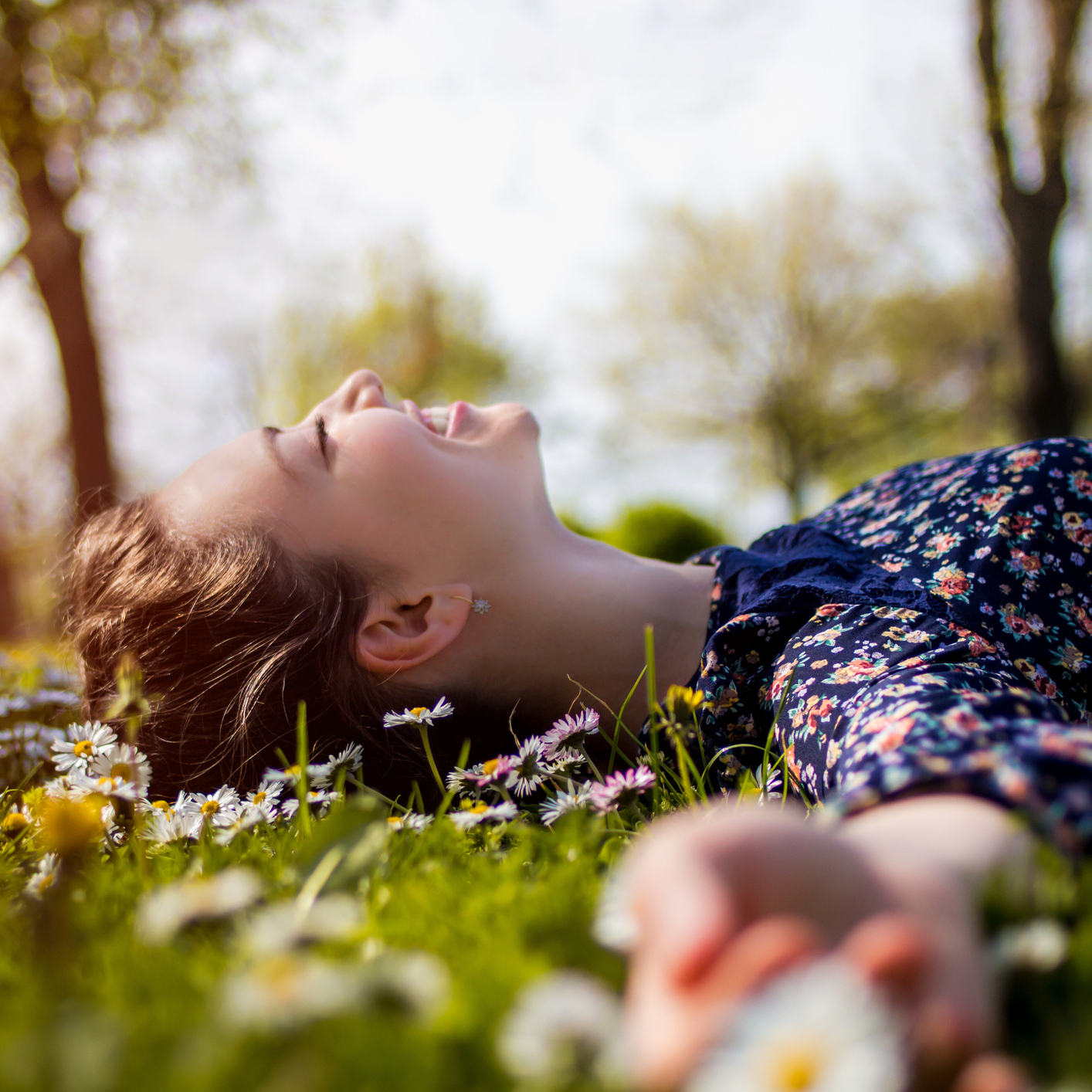 woman lying in field of flowers and smiling