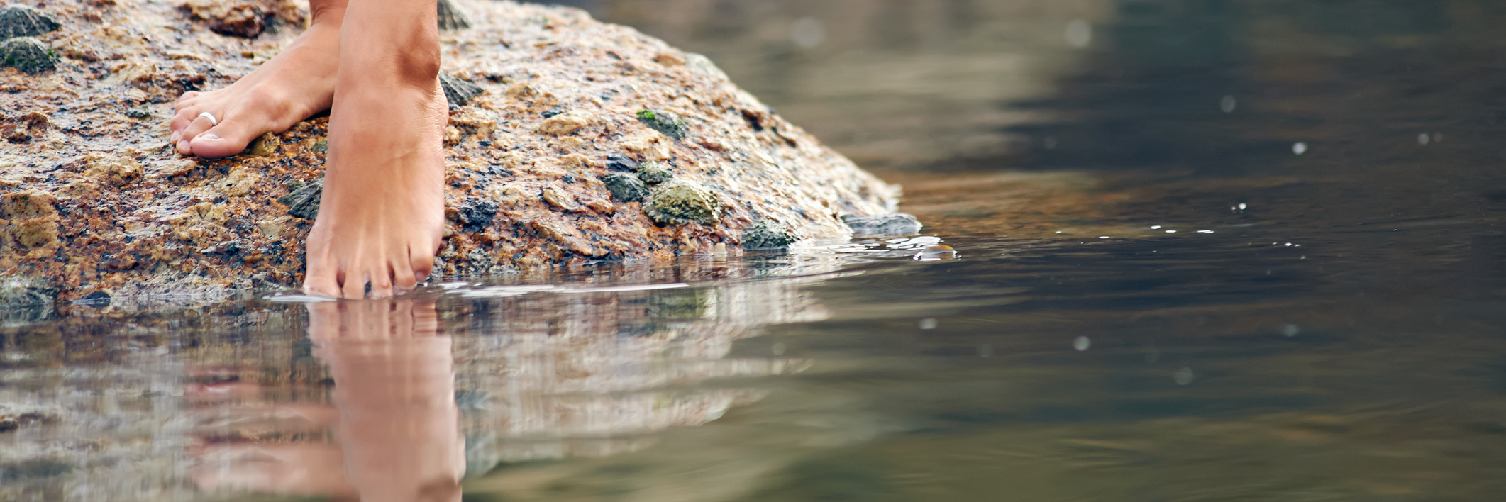 9 Ways to Help Calm Your Chronic Pain in the Summer Heat Woman putting her feet into the water.