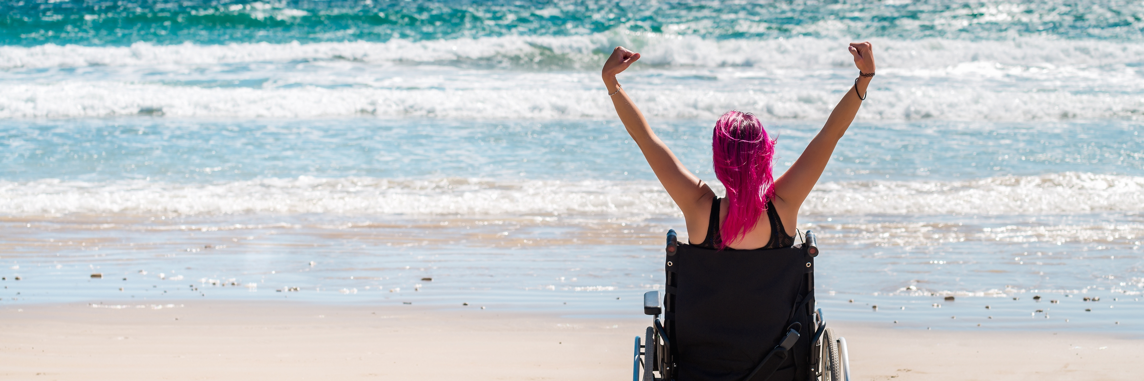 Disabled woman in a wheelchair on the beach.