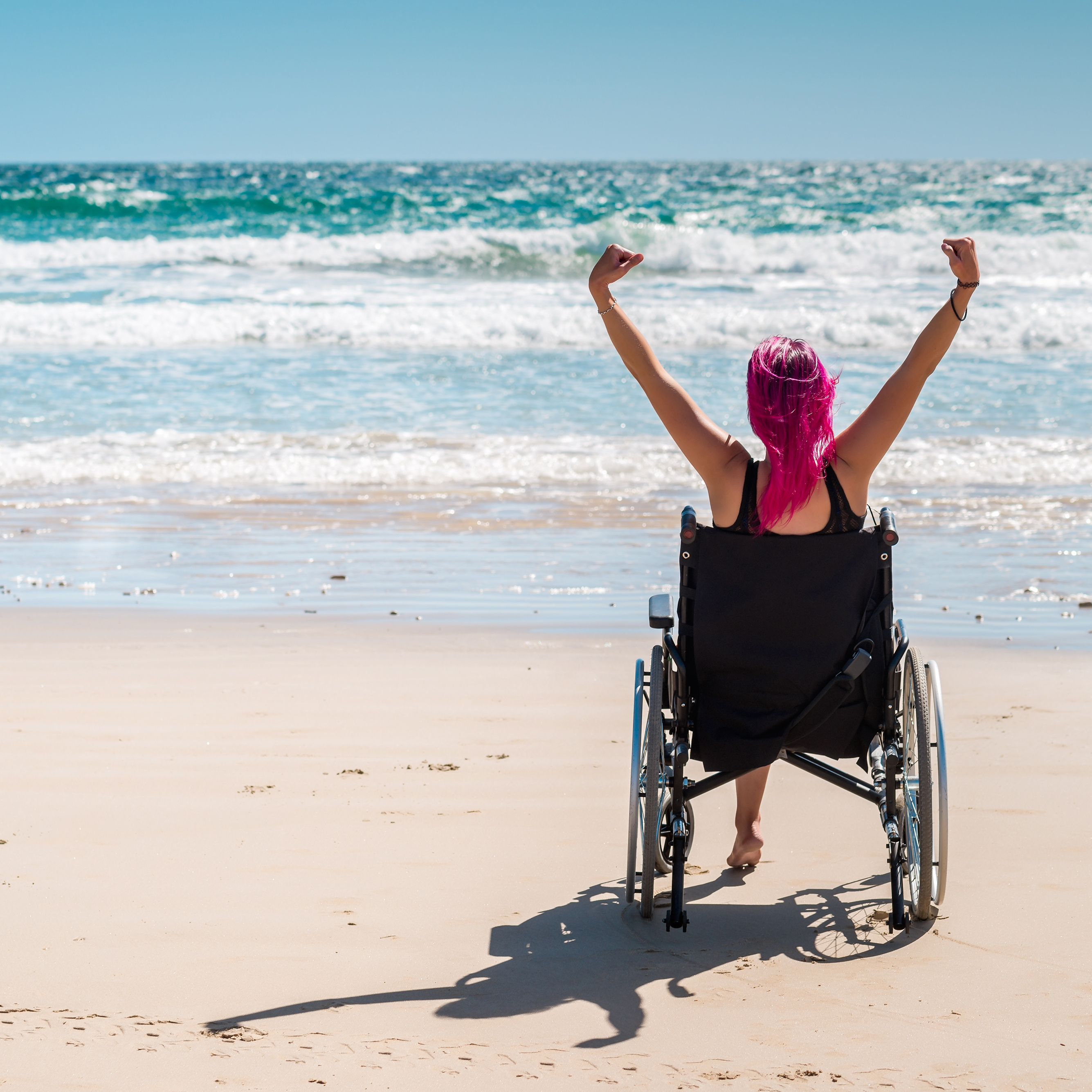 Disabled woman in a wheelchair on the beach.