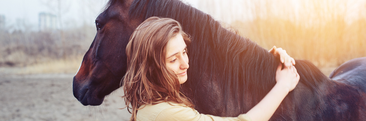 Horses Help Veterans Struggling With Post Traumatic Stress Disorder A woman hugging a horse