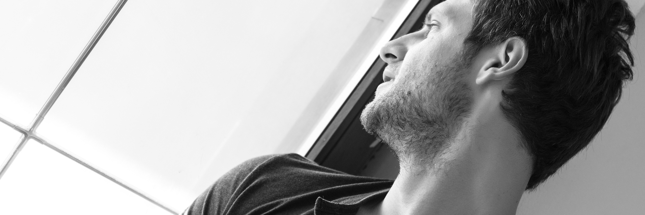 Words of Wisdom With My Younger Self About My Mental Illness black and white photo of man looking out window thoughtfully