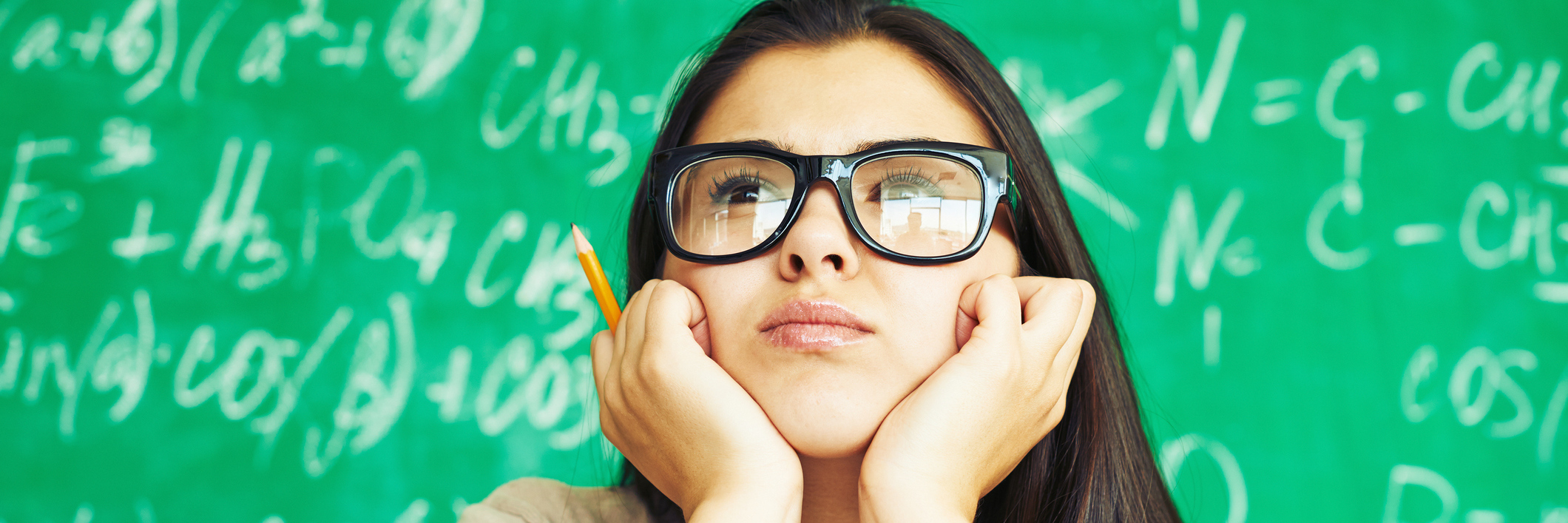 student sitting in front of a blackboard