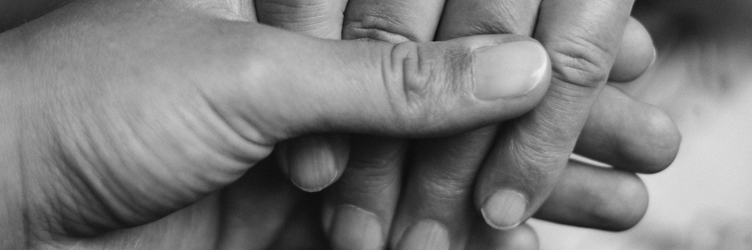 Practical Ways to Help Grieving Loved Ones Two people holding hands in supportive gesture