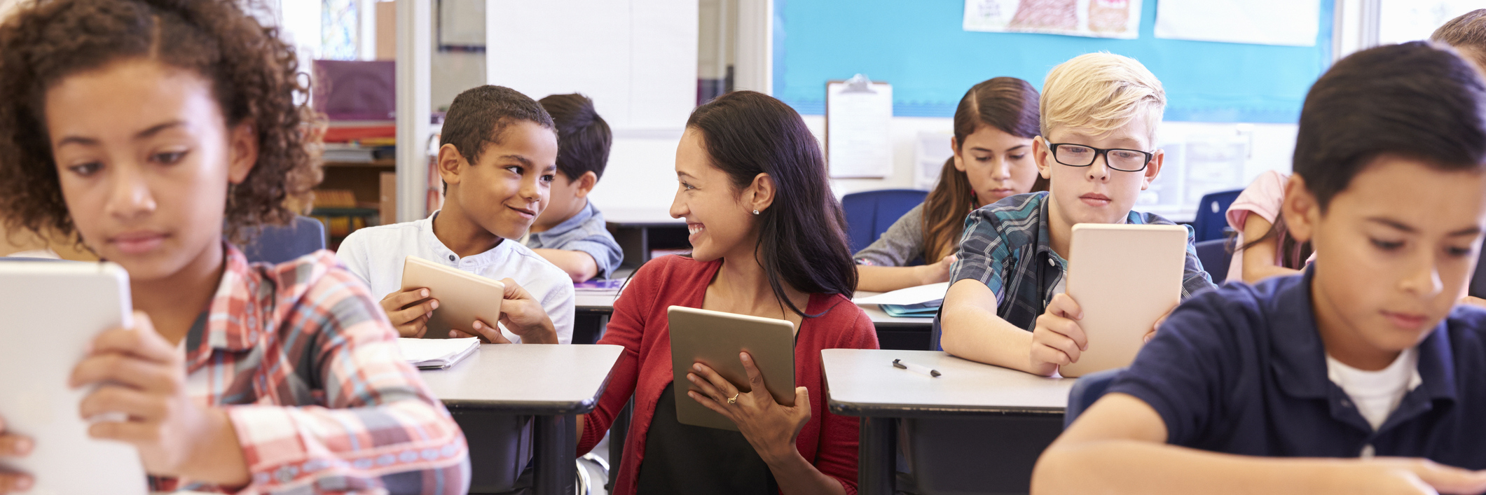 Pauline Hanson and Disability in Australian Schools Teacher among kids with computers in elementary school class.