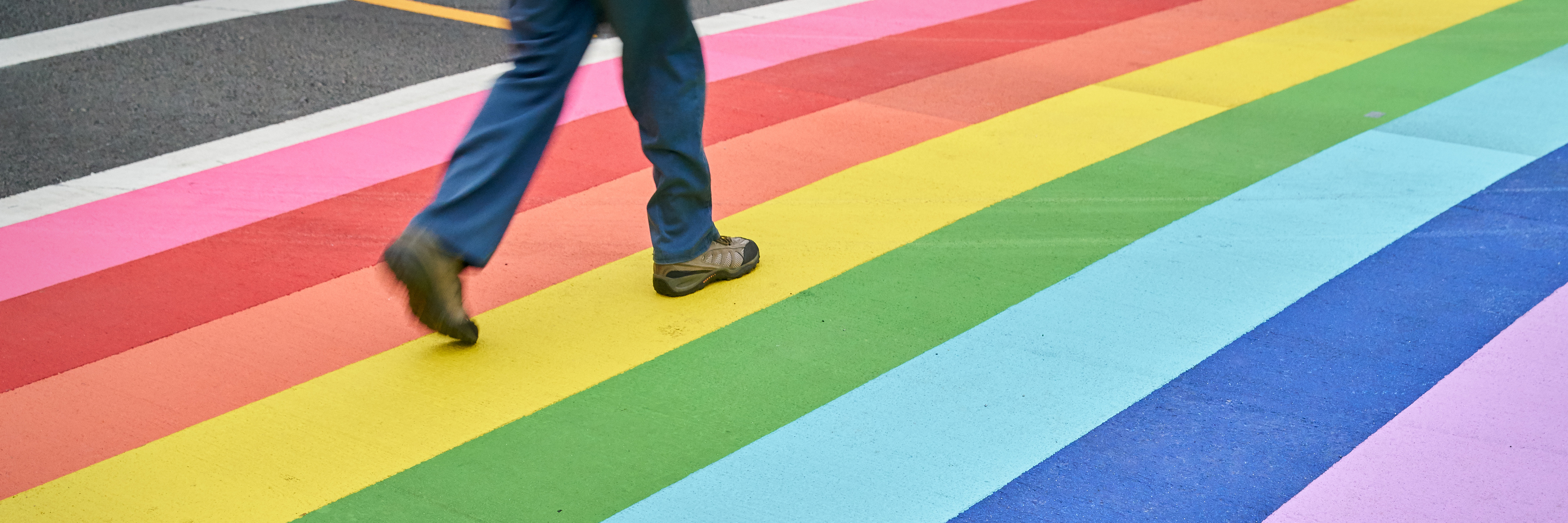 Finding Pride as a Gay Man With a 'Sitting Disability' A pedestrian using the rainbow colored crosswalk in downtown Vancouver.