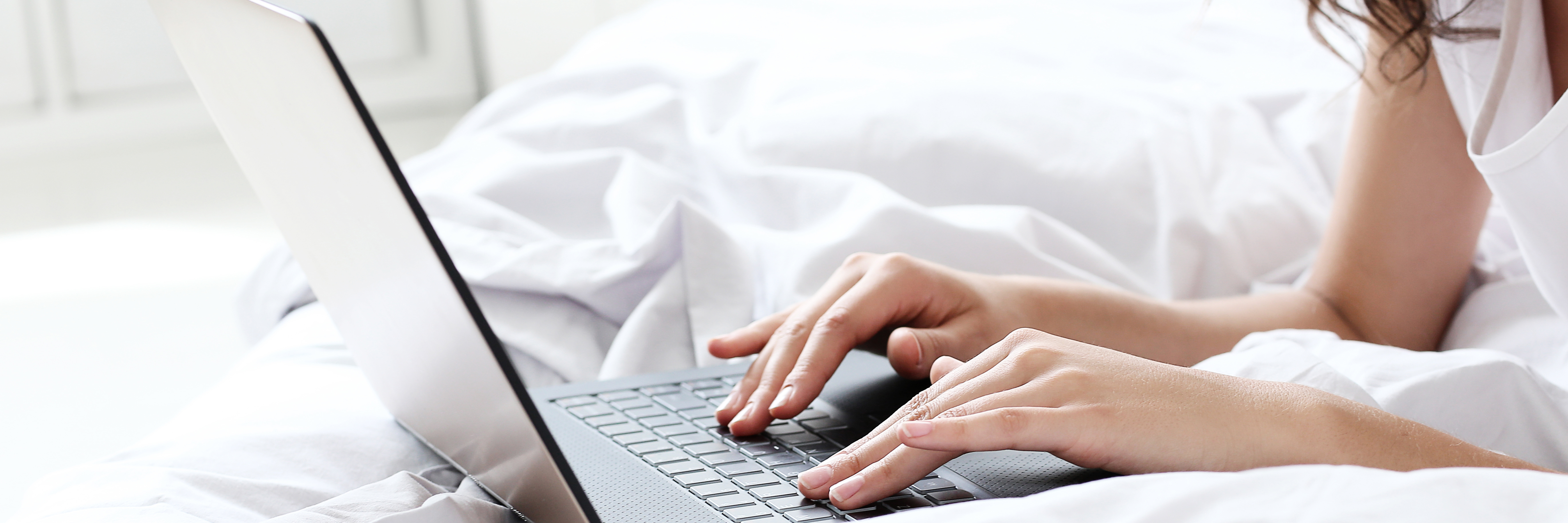 How Freelancing Helps Me Accept My Depression close up of woman working on laptop while lying on bed