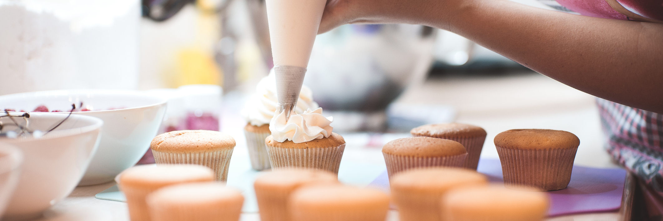 Using Baking to Cope With Lupus and Crohn's Disease woman frosting a batch of cupcakes