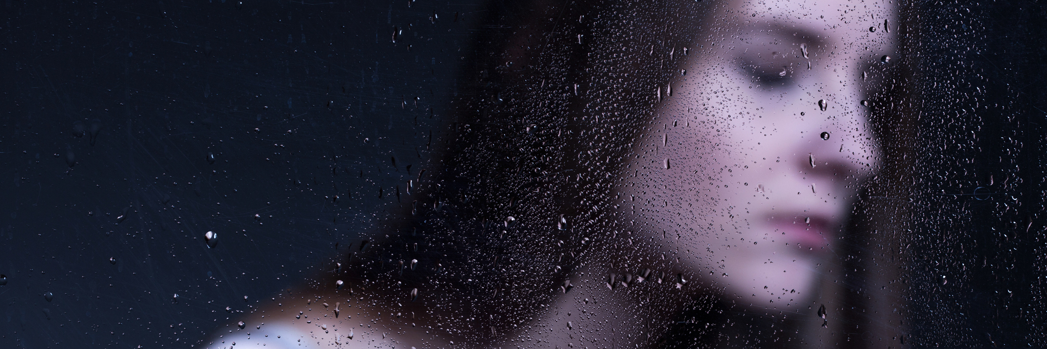 When I Find Myself in 'Lyme Hell' Woman stands behind glass with drops of water covering it.