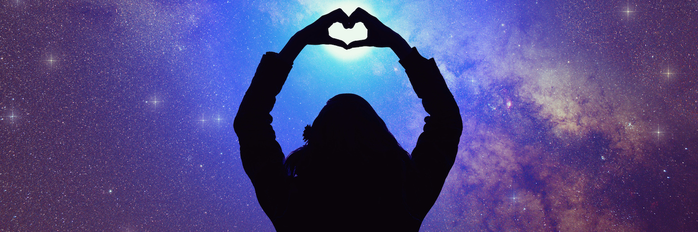Autism Makes Me Who I Am — and I'm Proud of That Silhouette of woman making heart shape with hands, with arms extended toward starry night sky