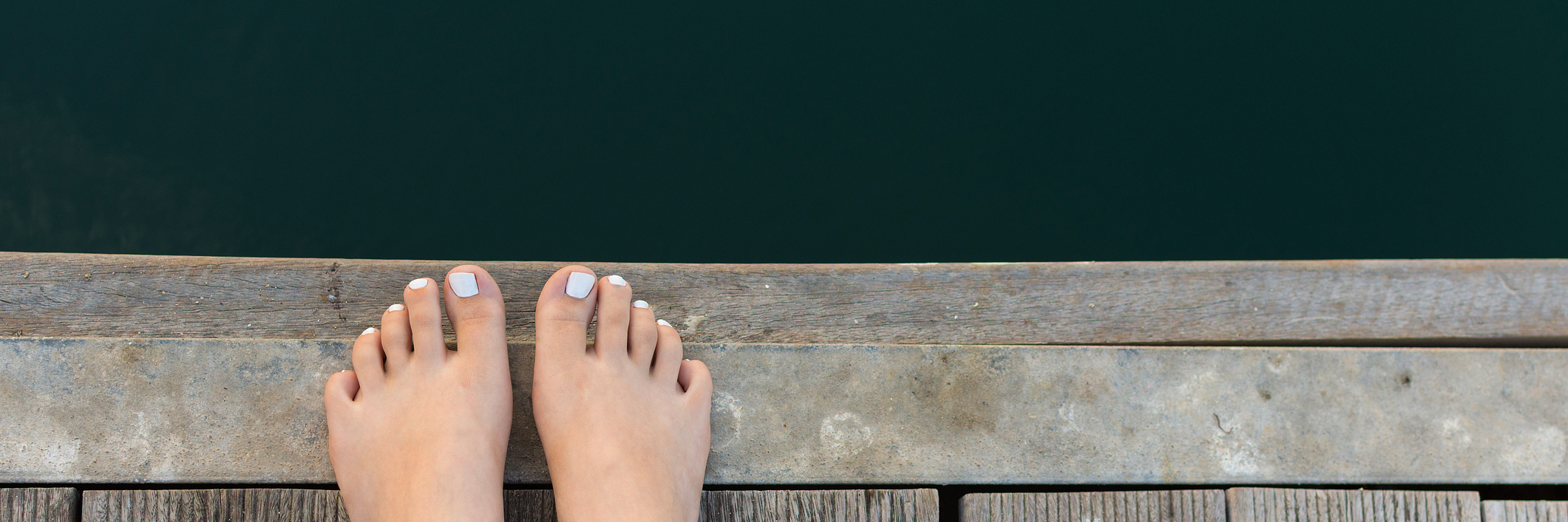 Mal de Debarquement Syndrome: Lessons Learned From Rare Disease woman's feet on wooden pier overlooking water