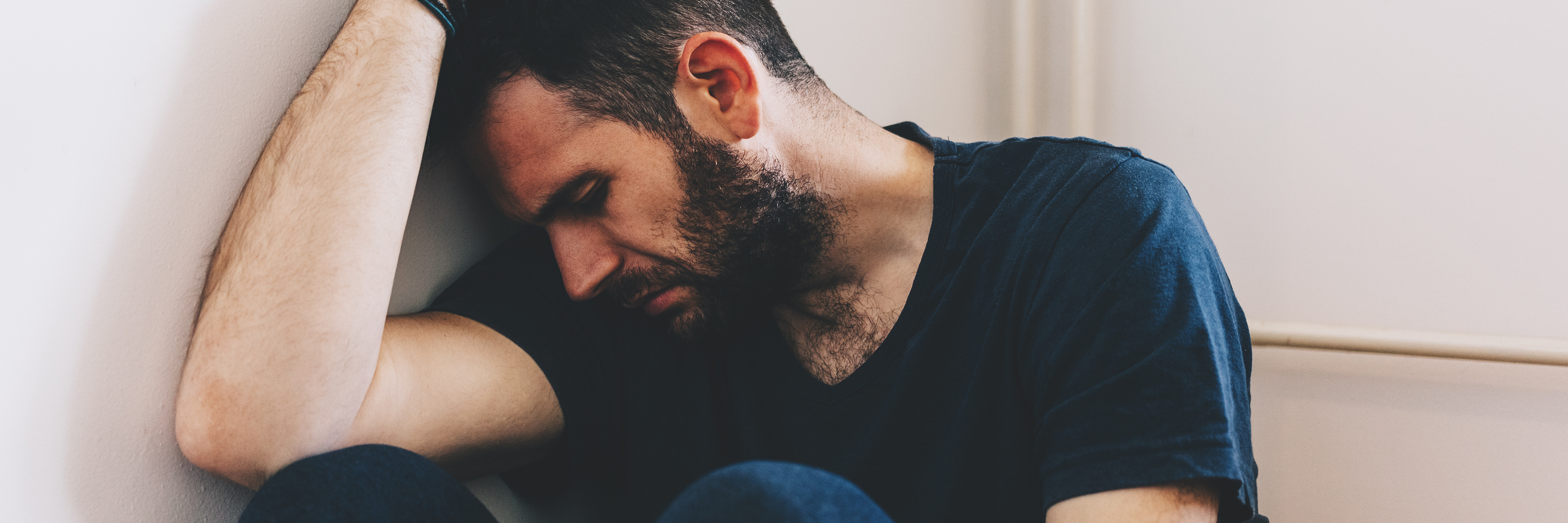 My Experience as a Man With Borderline Personality Disorder man with depression sitting in corner of room resting head on arm