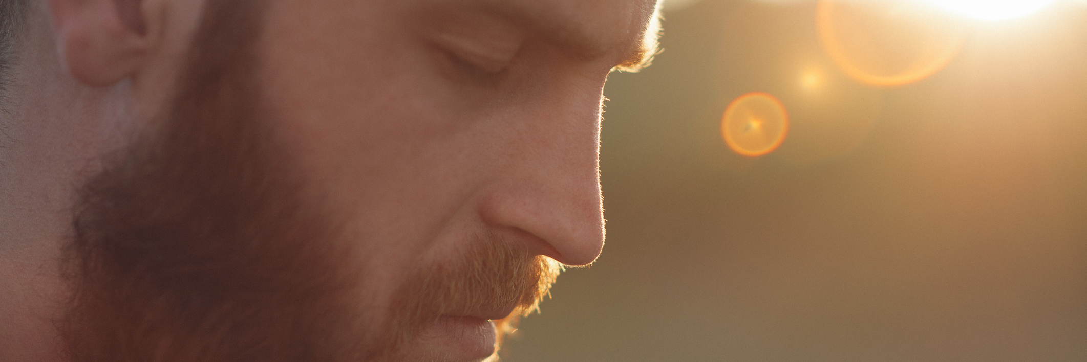 man with red beard standing outside in the sunlight