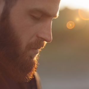 man with red beard standing outside in the sunlight