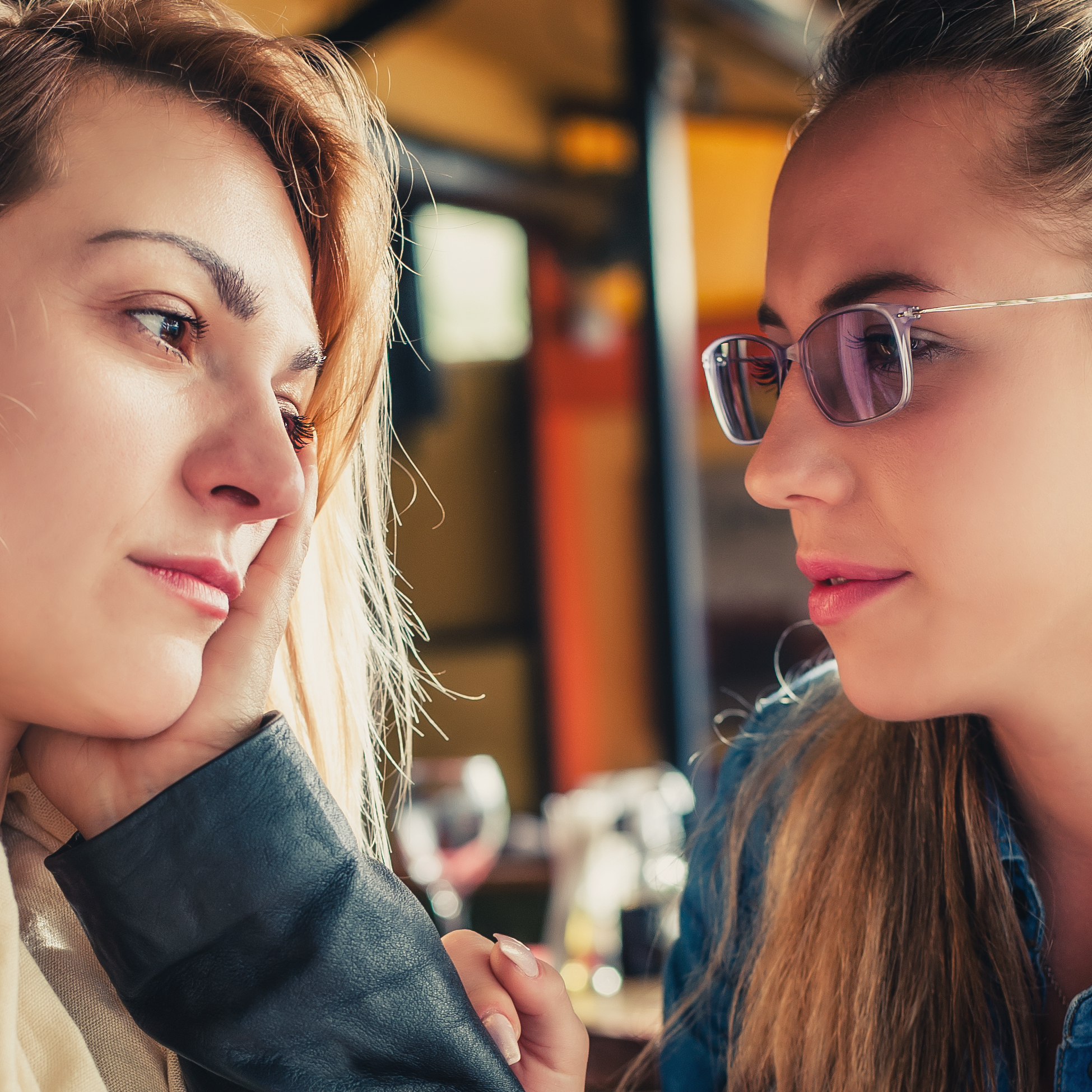 two young women talking in restaurant serious conversation looking sad