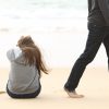 guy walking away from girl sitting on the beach