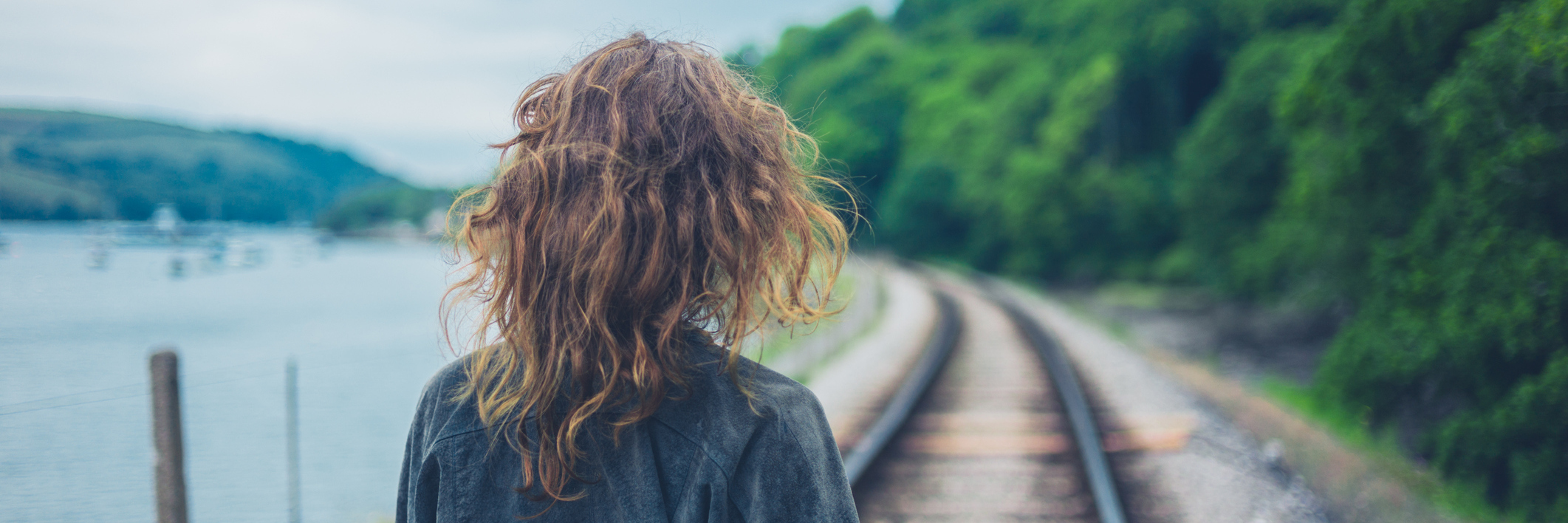 young woman walking along railroad tracks