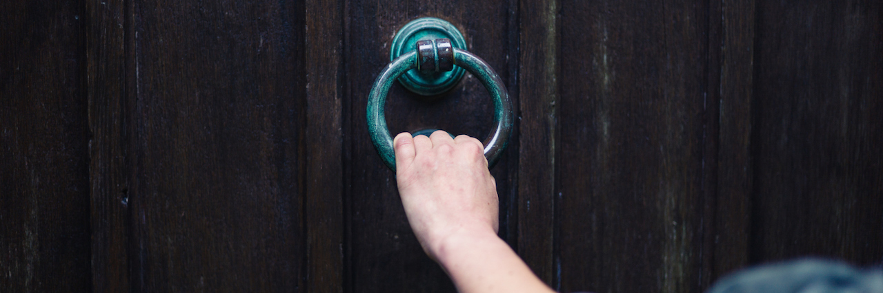 hand holing onto a door knocker