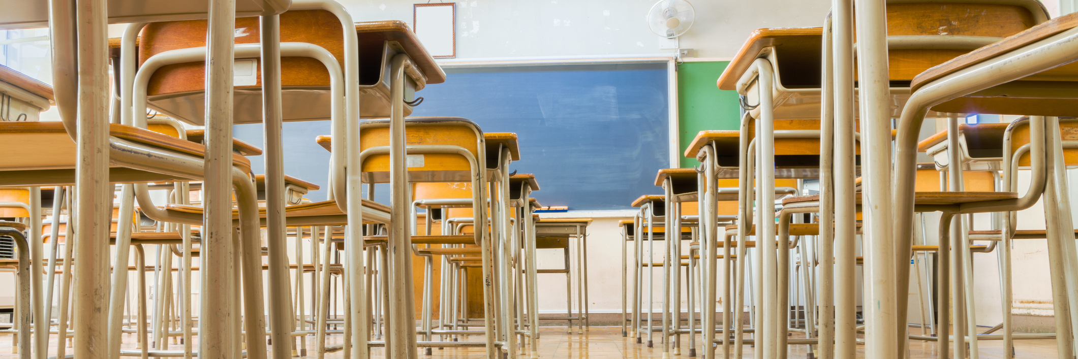 How Teaching Saved Me in the Midst of Depression A Japanese classroom with desk and tables and blakckboard is taken from low angle.