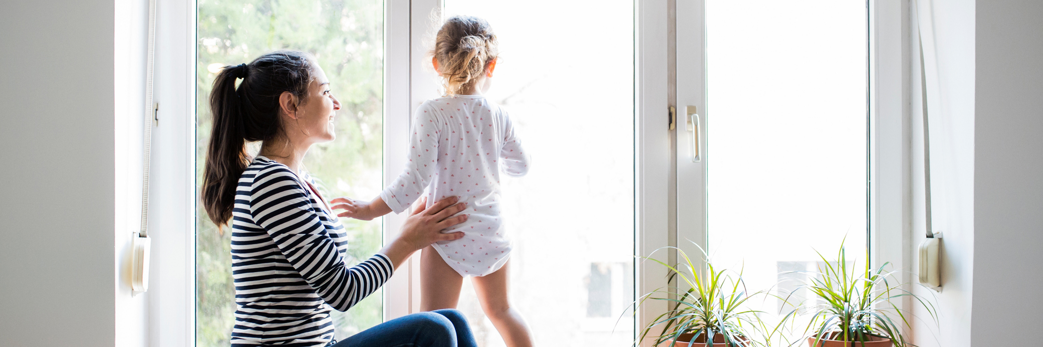 Summer Activities to Keep Your Kids Busy for Moms With Chronic Illness mother holding daughter as she looks out the window