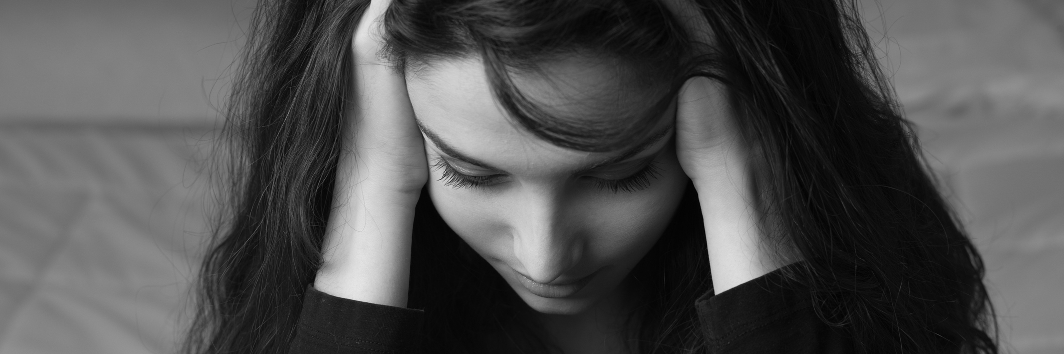 black and white photo of woman holding her head in pain