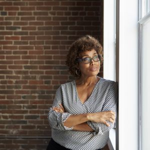 woman leaning against a window looking outside