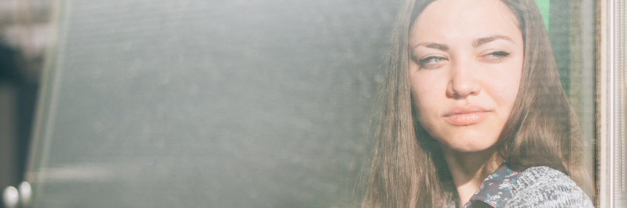 What It Feels Like When Your Antidepressants Stop Working young woman staring out the window with a cup in her hand