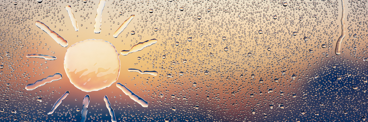 My Depression Is Like a Sun Shower rain on a window with a sun drawn on it