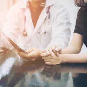 Doctor and patient chat over table.