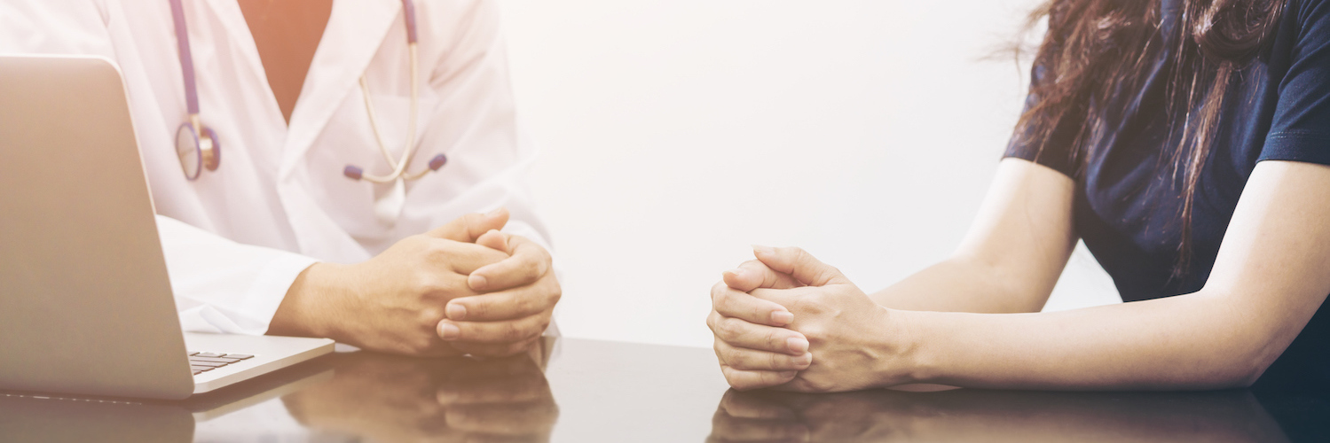 Receiving the News That I Likely Have Papillary Thyroid Cancer Doctor and patient at a table with arms resting on table and hands folded, having a conversation