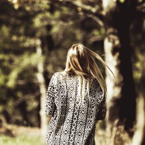 young woman walking in park rear shot muted colours