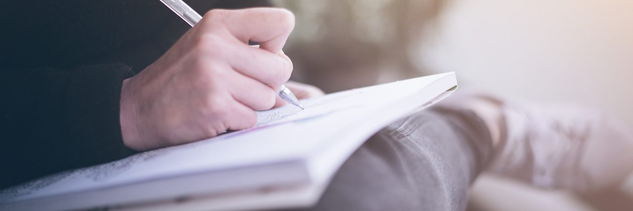 How Journaling Helped Me Manage My Anxiety and Panic Attacks A woman writing in her journal