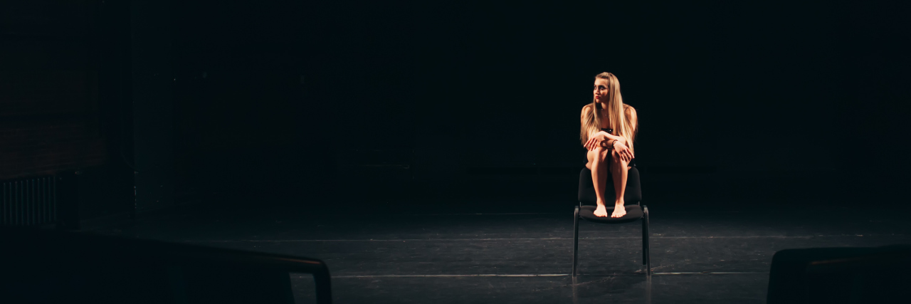 How I Came to Accept I Couldn't Force My Recovery From Depression female actor alone on stage barefoot sitting on chair