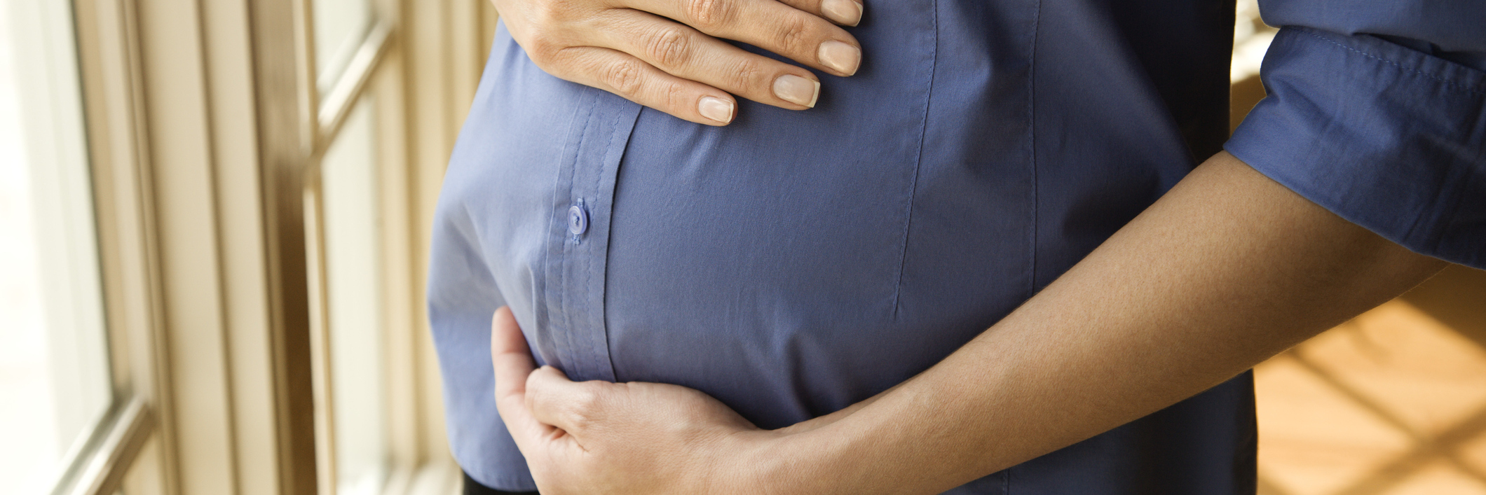 Staying Sober While Pregnant Pregnant woman wearing a denim shirt holding her belly
