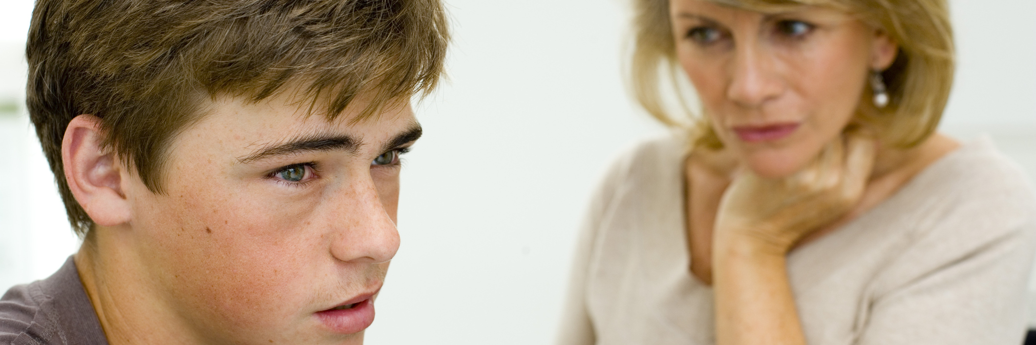 What to Know About Child Self-Harming and How to Help mother talking to teenage son both looking upset