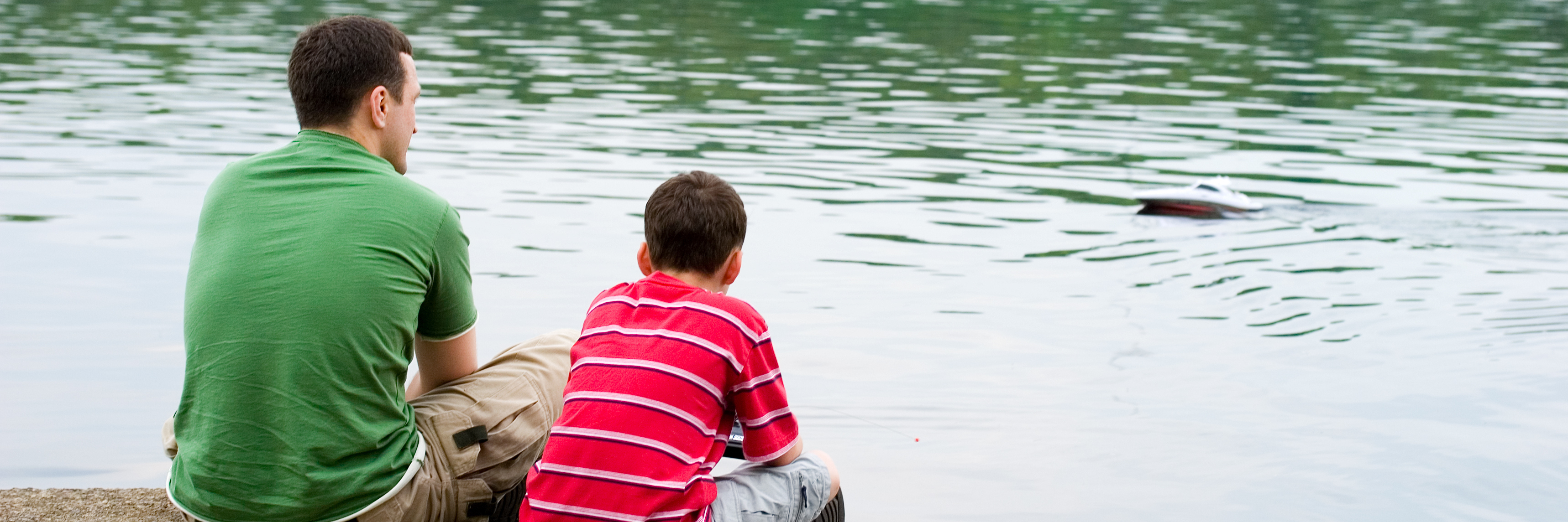 Talking to My Son About Depression father and son sitting on pier talking by lake