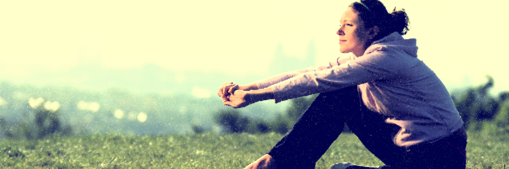 Can't Stop Tics Due to Tourette Syndrome Young woman sitting on grass, cityscape in background